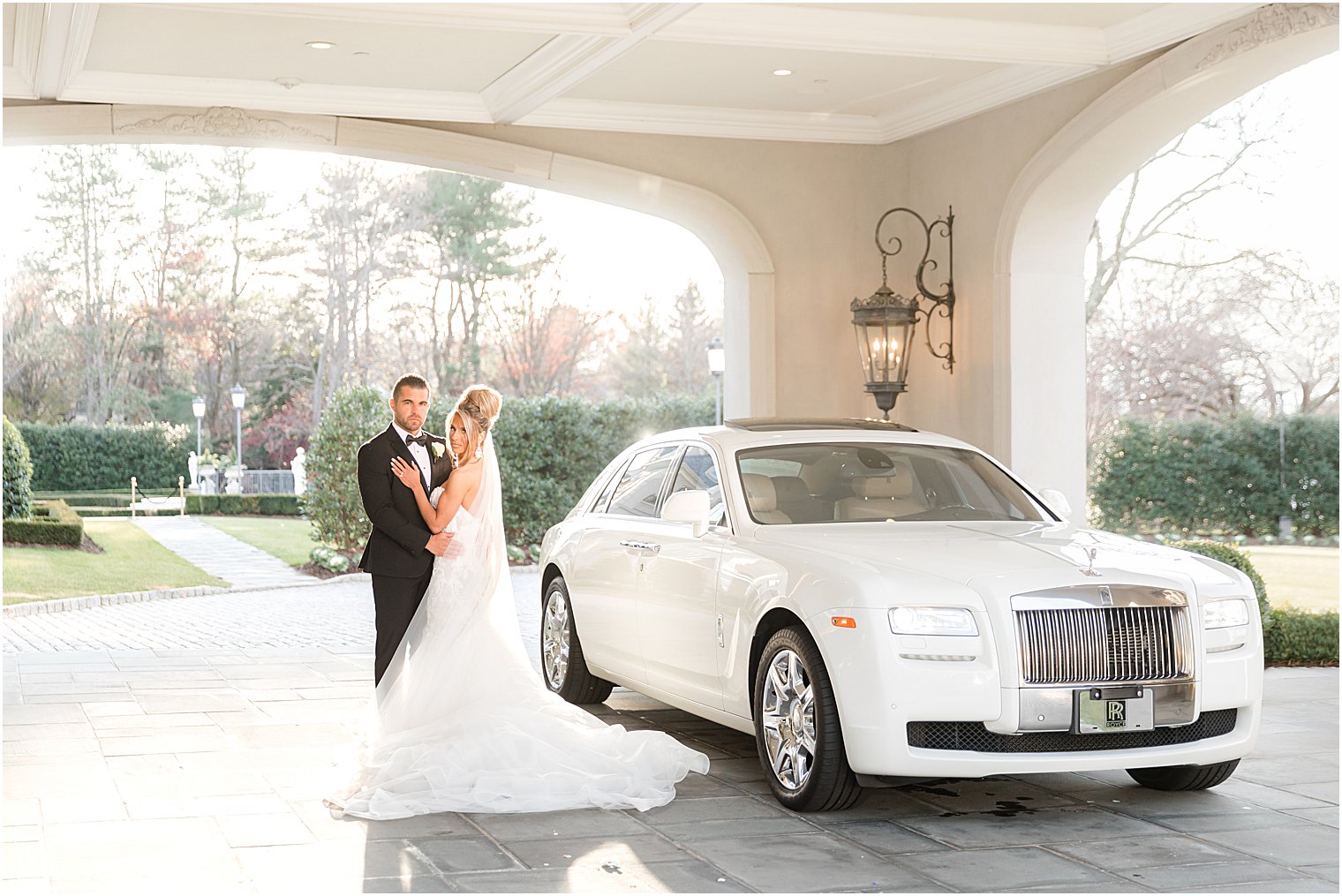 bride and groom hug by white Rolls Royce at Park Chateau Estate 