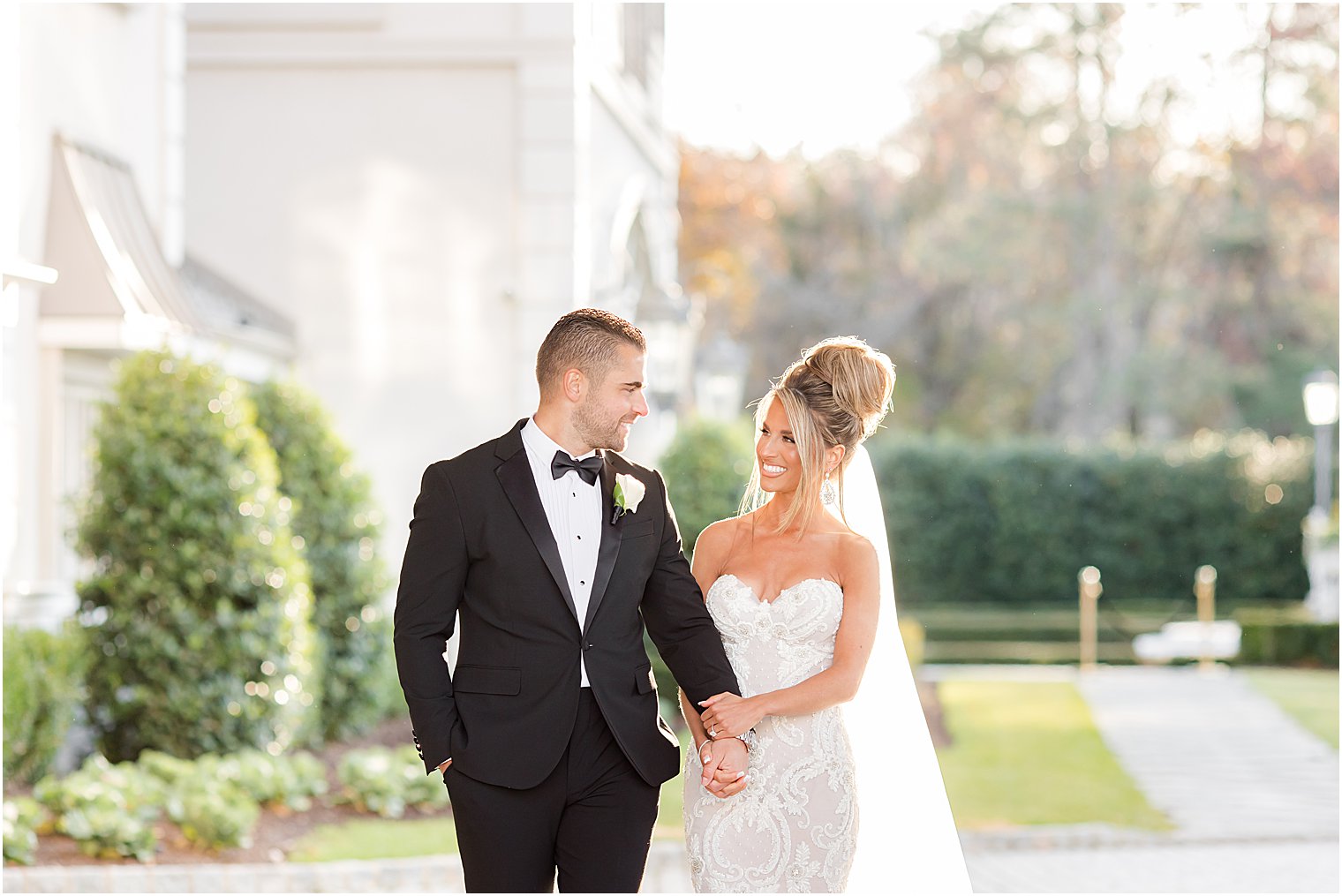 newlyweds hold hands walking outside Park Chateau Estate 