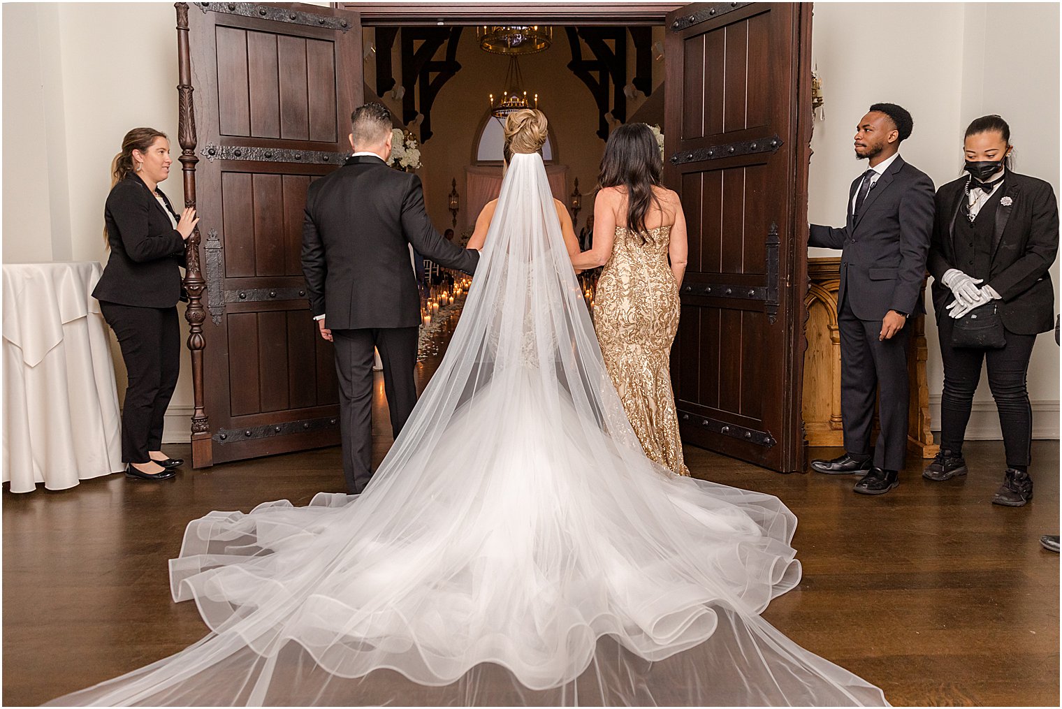 bride prepares to walk down aisle with parents for winter wedding ceremony at twilight in Park Chateau Estate chapel