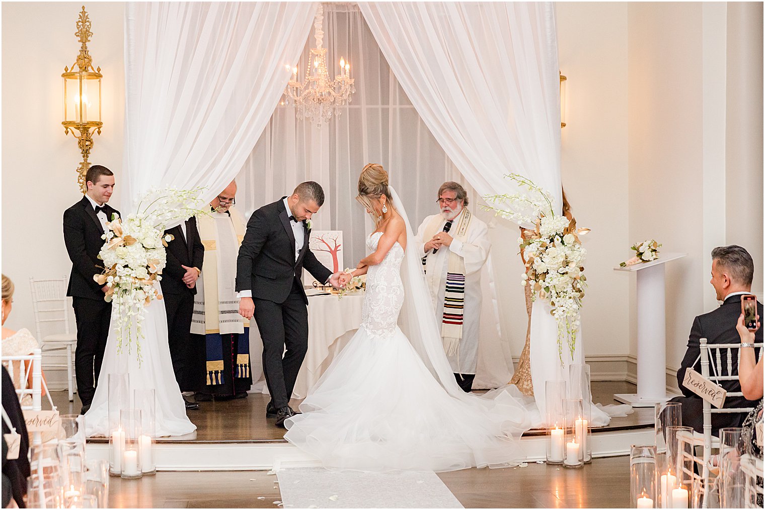 groom breaks glass during winter wedding ceremony at twilight in Park Chateau Estate chapel