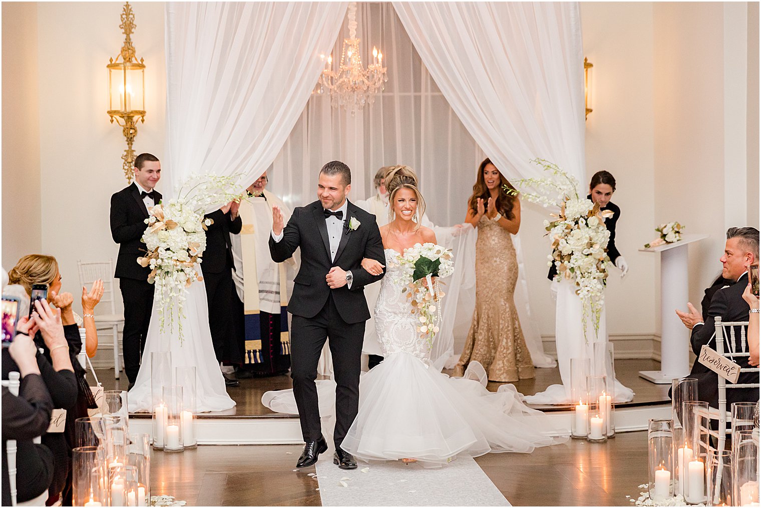 newlyweds recess up aisle after winter wedding ceremony at twilight in Park Chateau Estate chapel