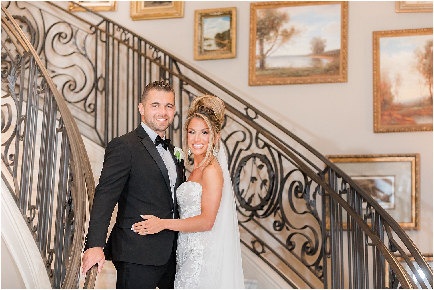 bride and groom hug by wrought iron banister on staircase at Park Chateau Estate