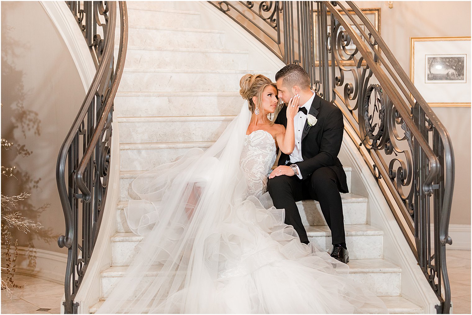 bride looks at groom sitting on steps during wedding portraits at Park Chateau Estate