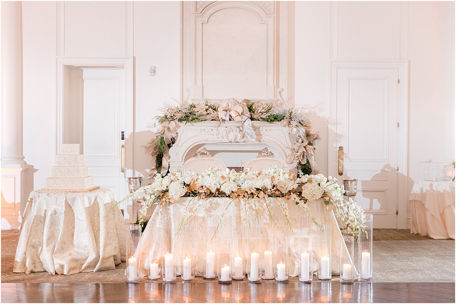 winter sweetheart table by fireplace with greenery draped on top