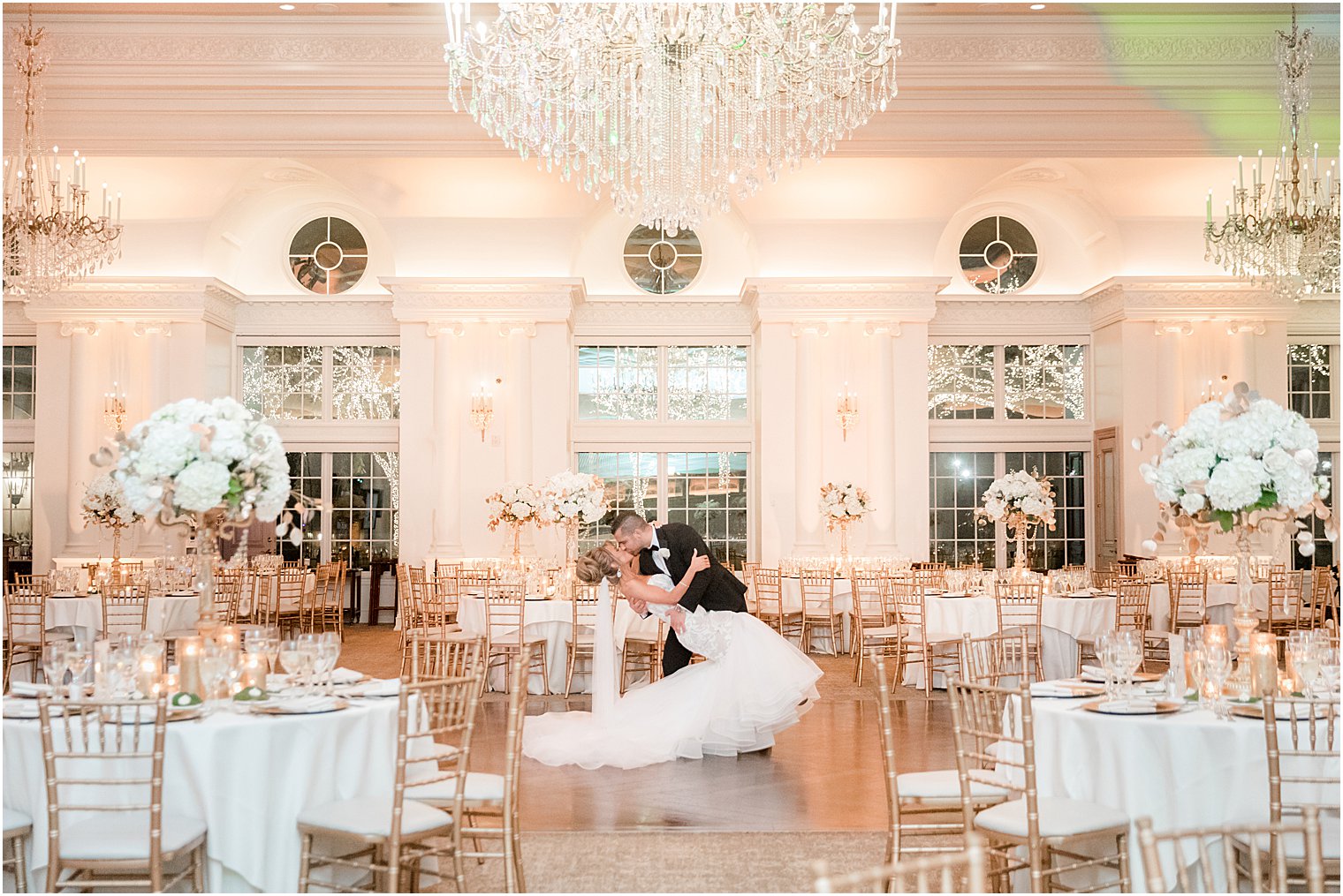 groom kisses bride dipping her in ballroom at Park Chateau Estate