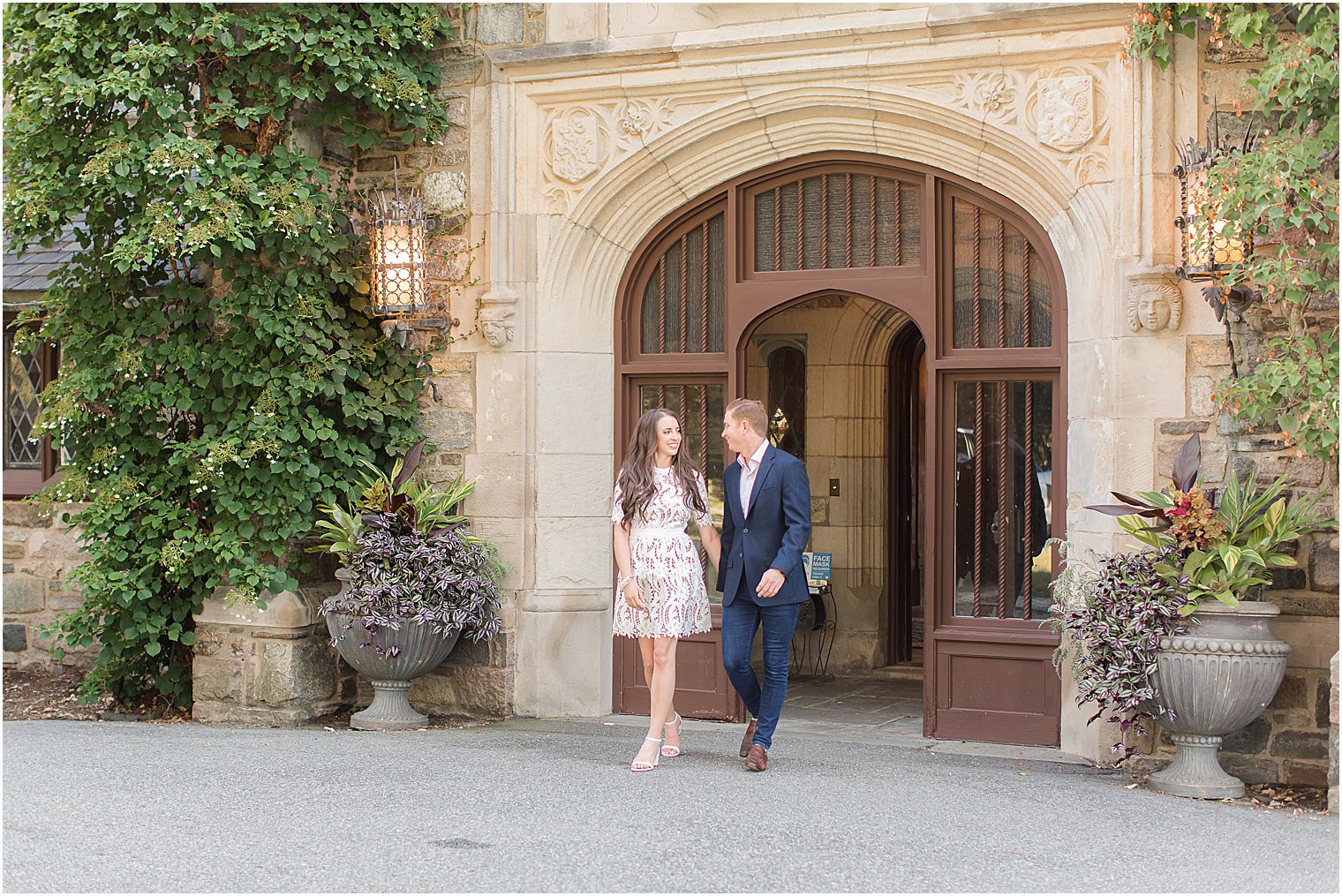 engage couple holds hands walking through building in Ringwood NJ