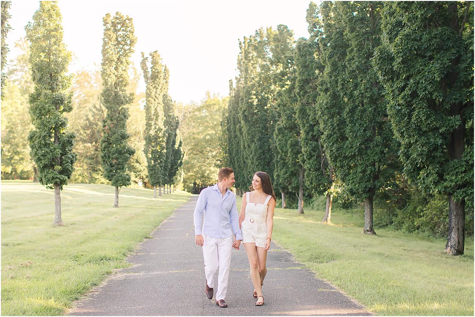 bride and groom hold hands walking down driveway