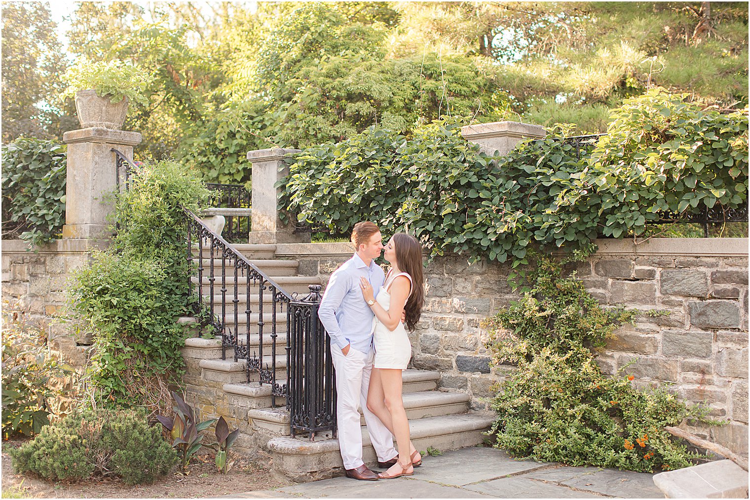 engaged couple kisses by stone staircase