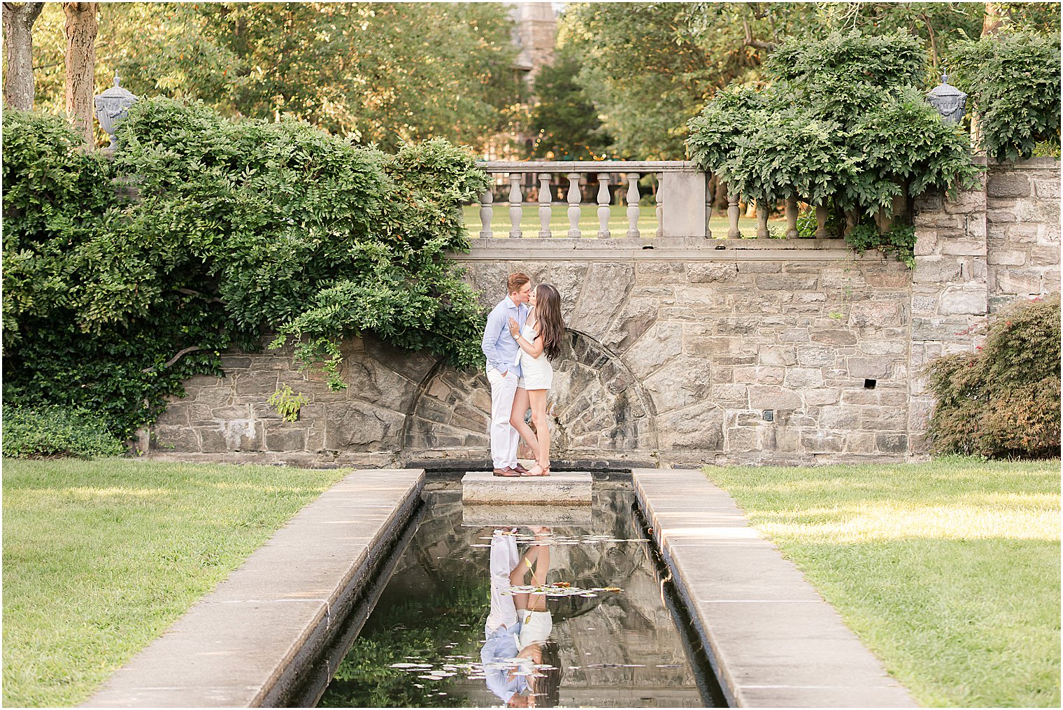 couple kisses at the end of pond at Skylands Manor