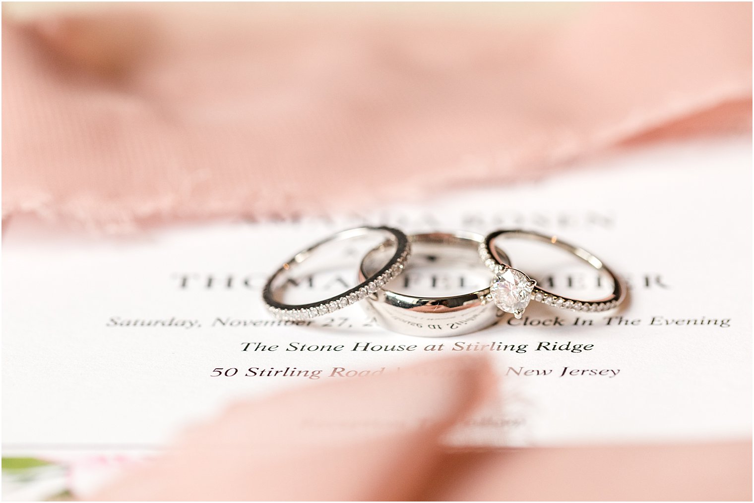 wedding rings rest on invitation for Warren NJ wedding