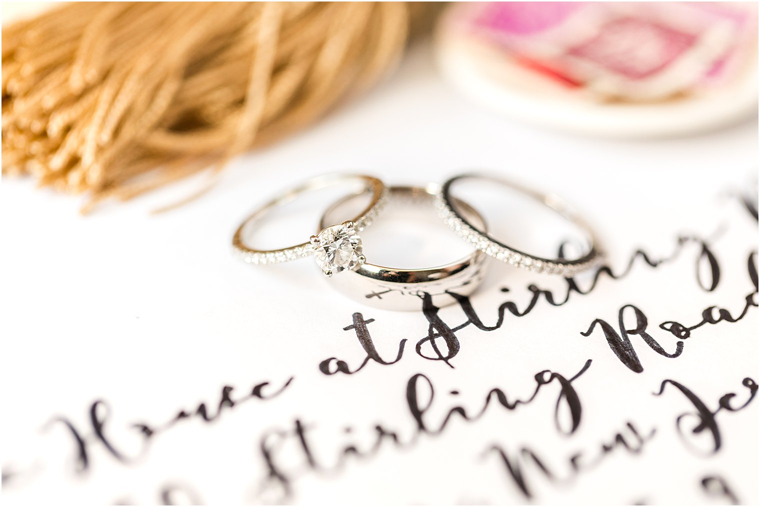 wedding bands rest on invitation suite