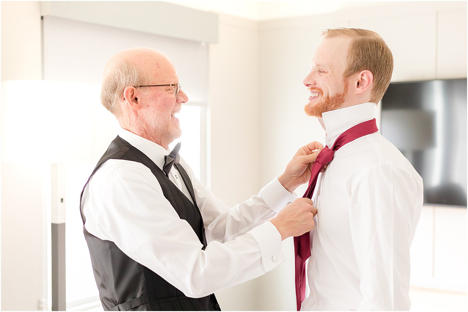 father helps groom adjust tie