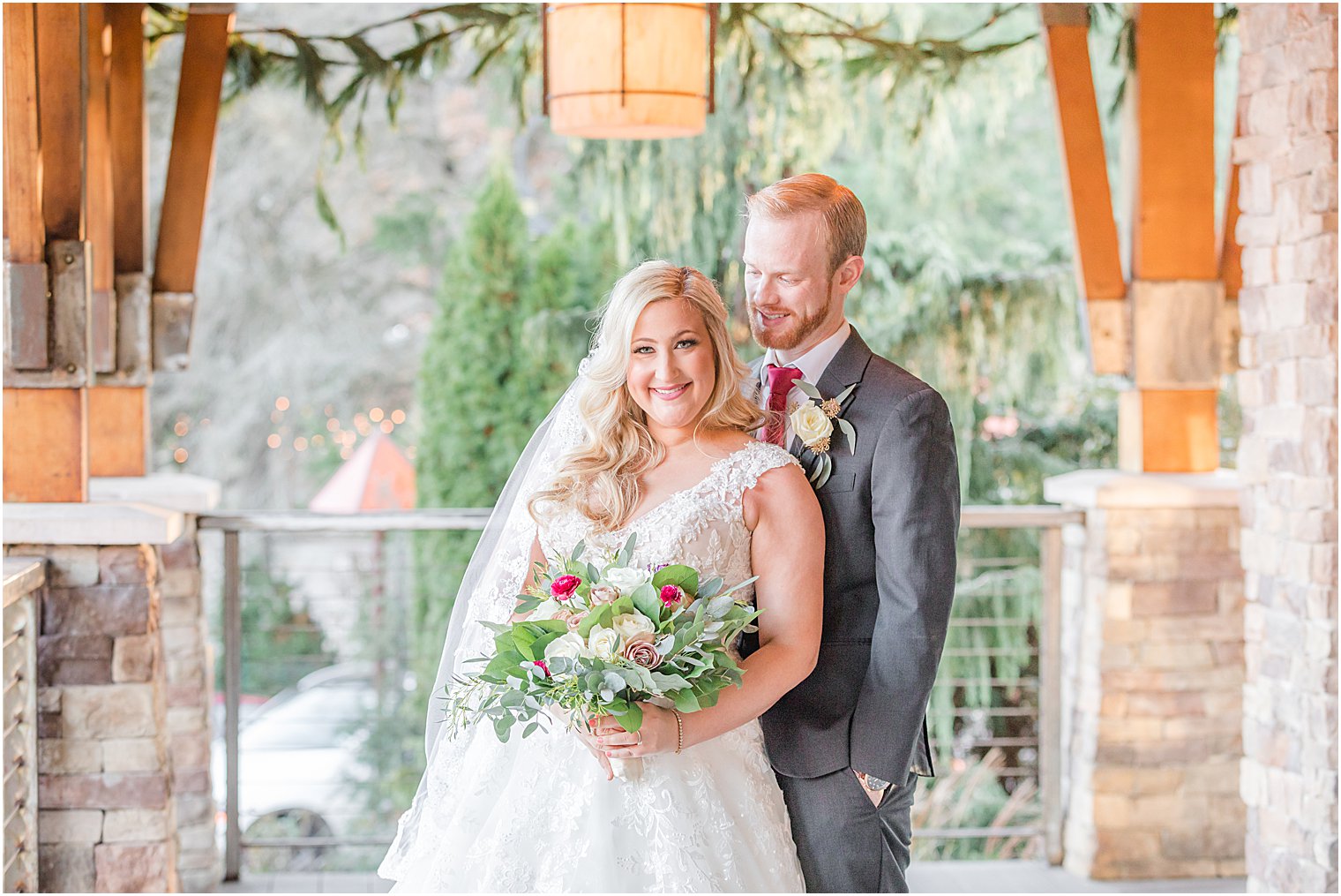 groom hugs bride from behind during fall wedding portraits 