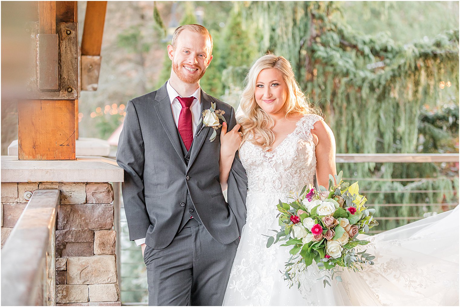 bride holds groom's arm during fall wedding photos at the Stone House at Stirling Ridge