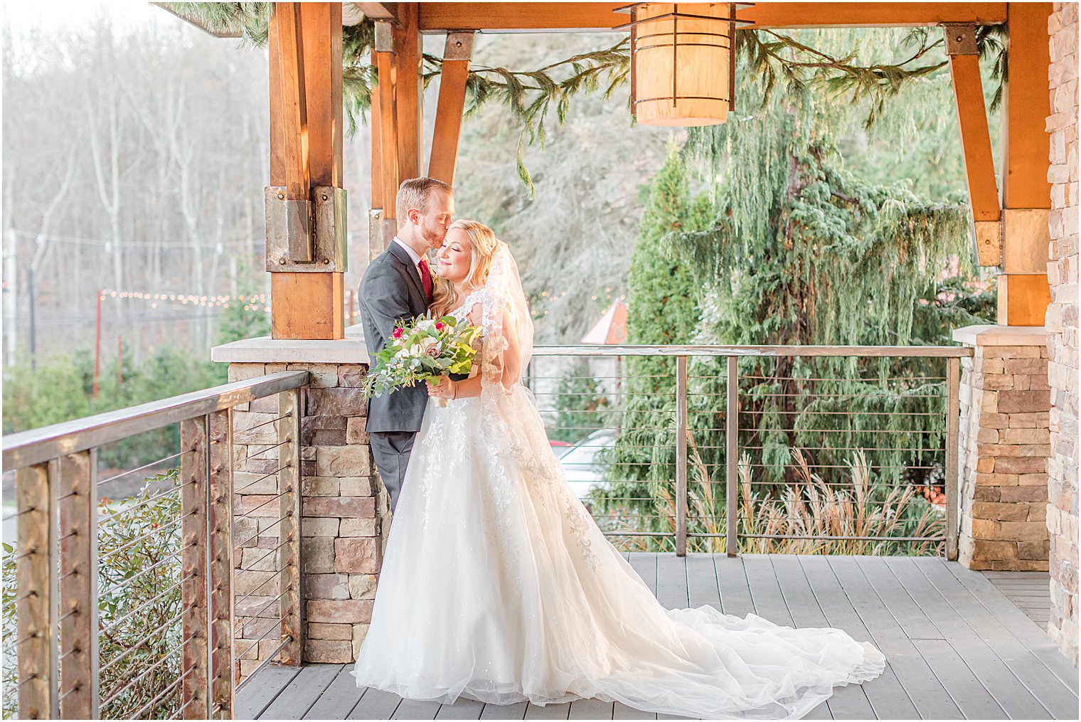 bride and groom smile together against pillar at the Stone House at Stirling Ridge