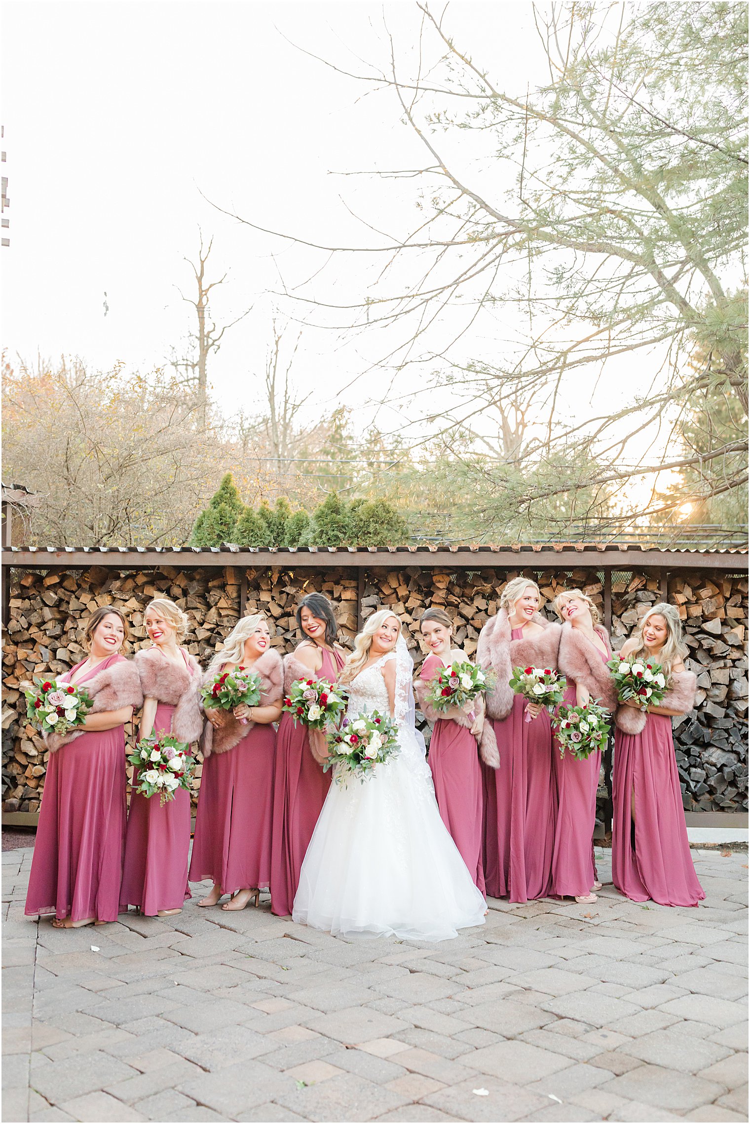 bride stands with bridesmaids in pink gowns