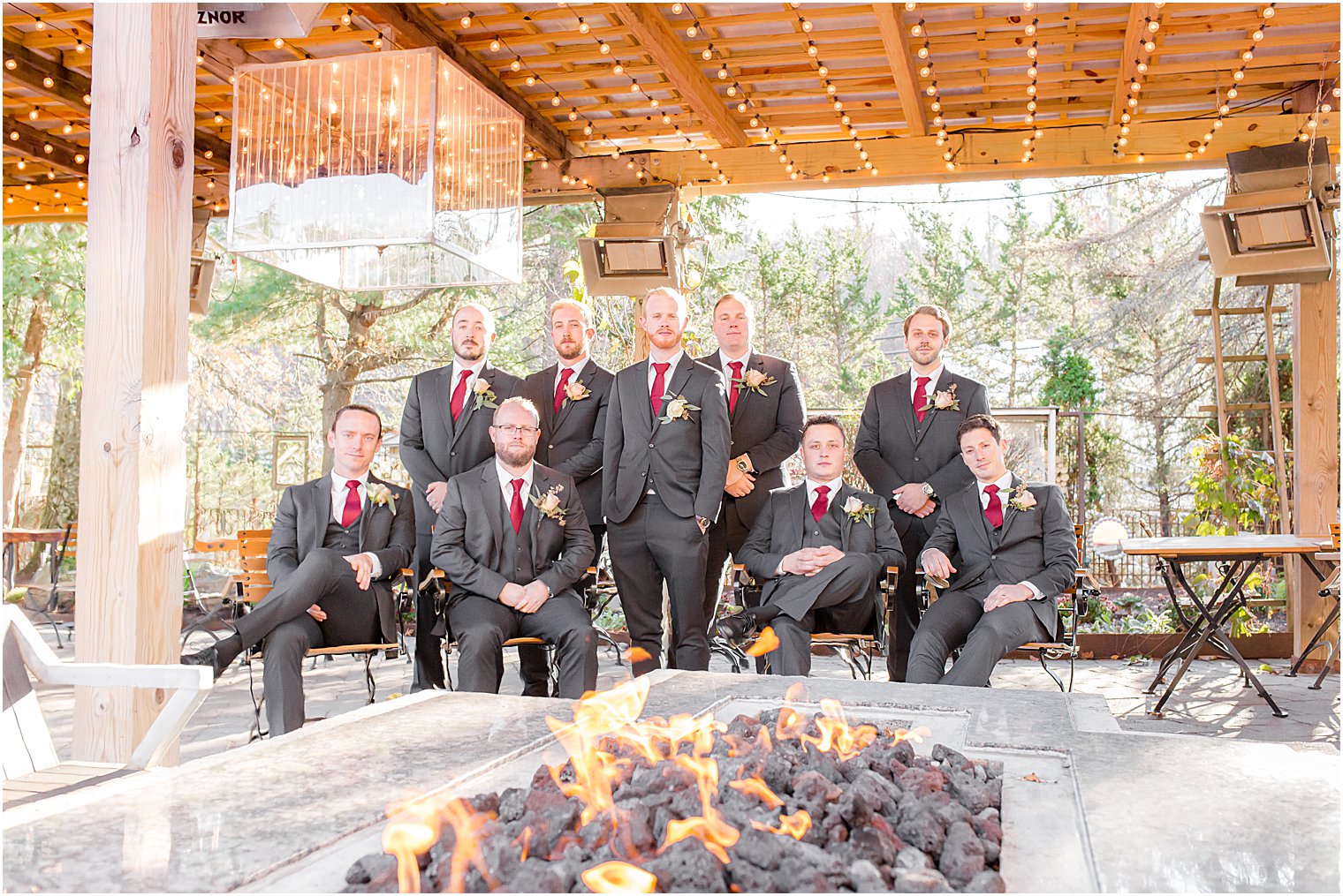 groom and groomsmen pose by fire pit