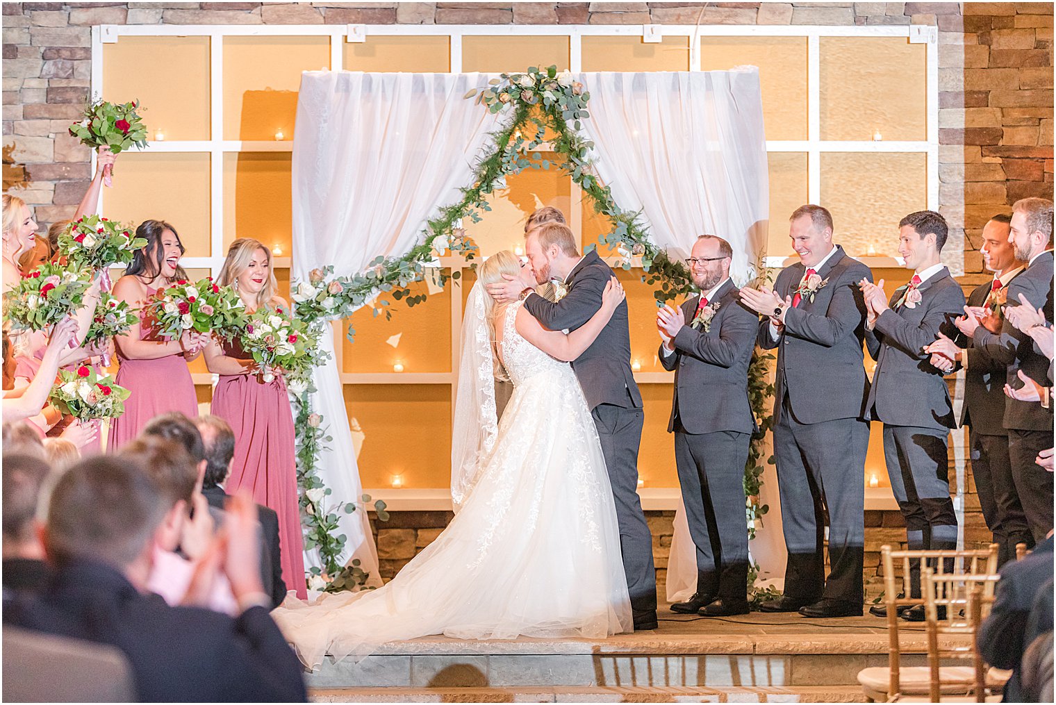 bride and groom kiss under arbor during fall wedding 