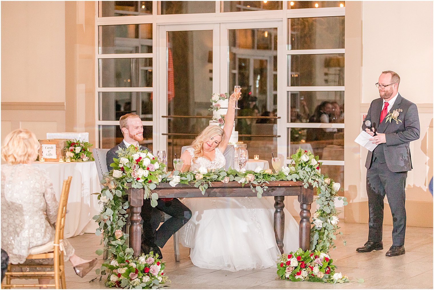 bride and groom laugh during toast with best man