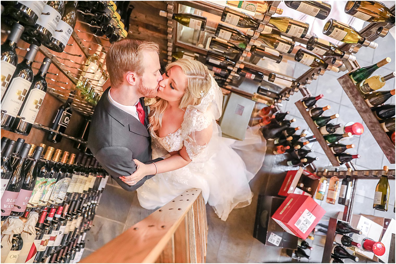 bride and groom kiss in wine cellar