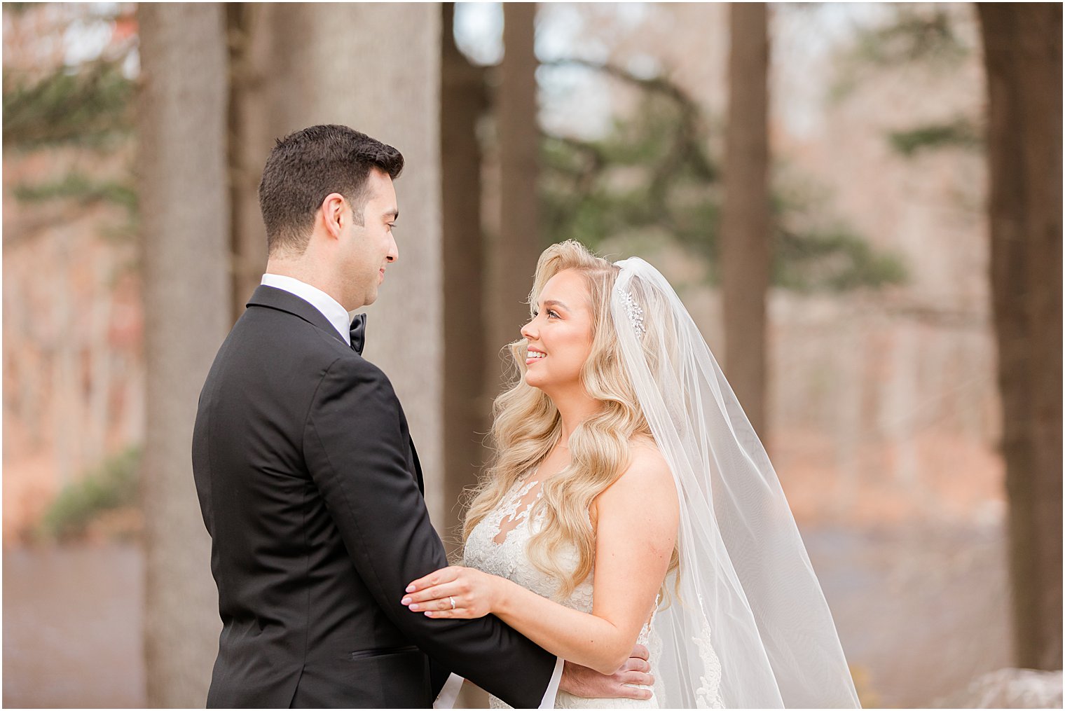 bride looks up at groom during first look at the Estate at Farmington Lake