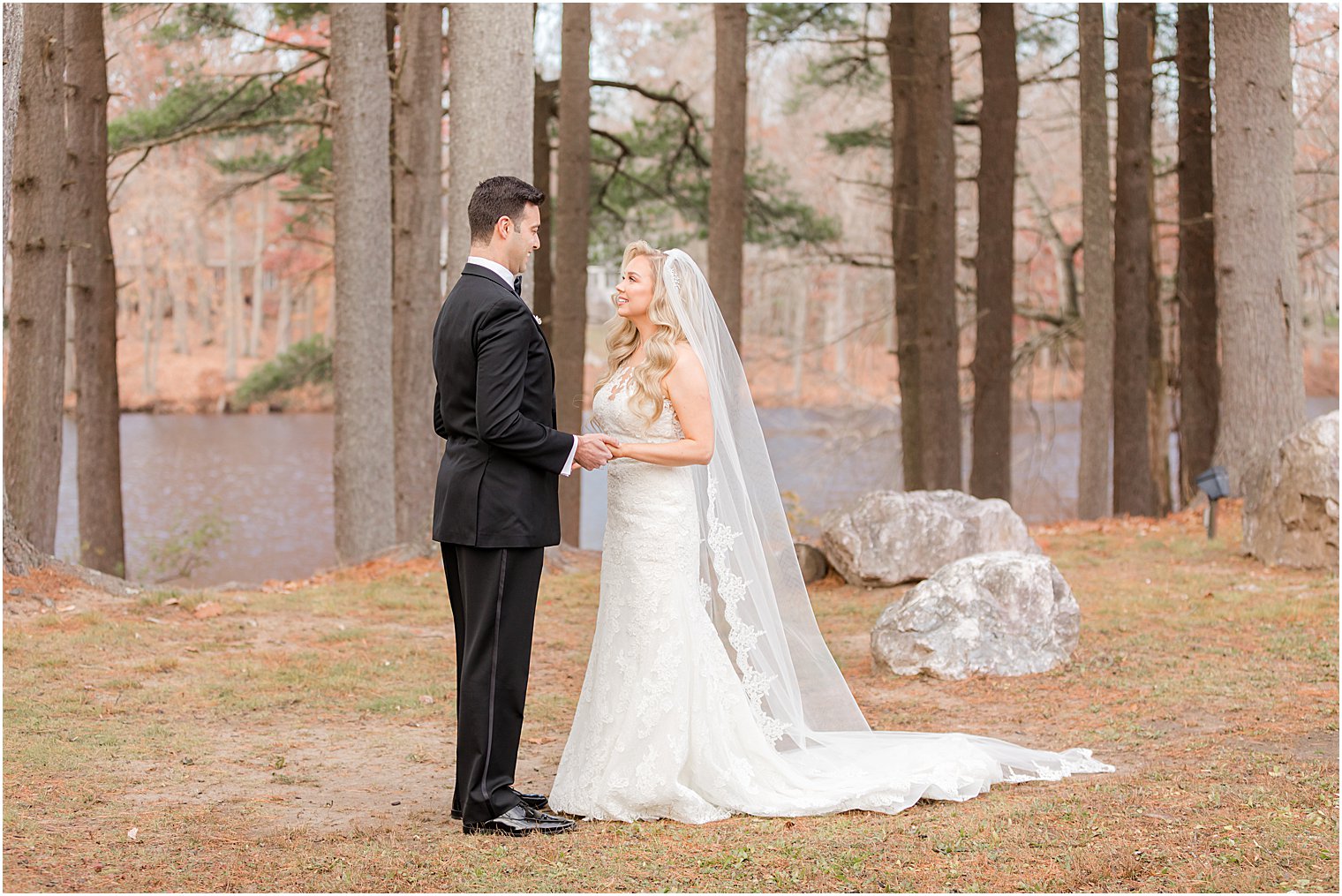 bride and groom hold hands in the woods at the Estate at Farmington Lake