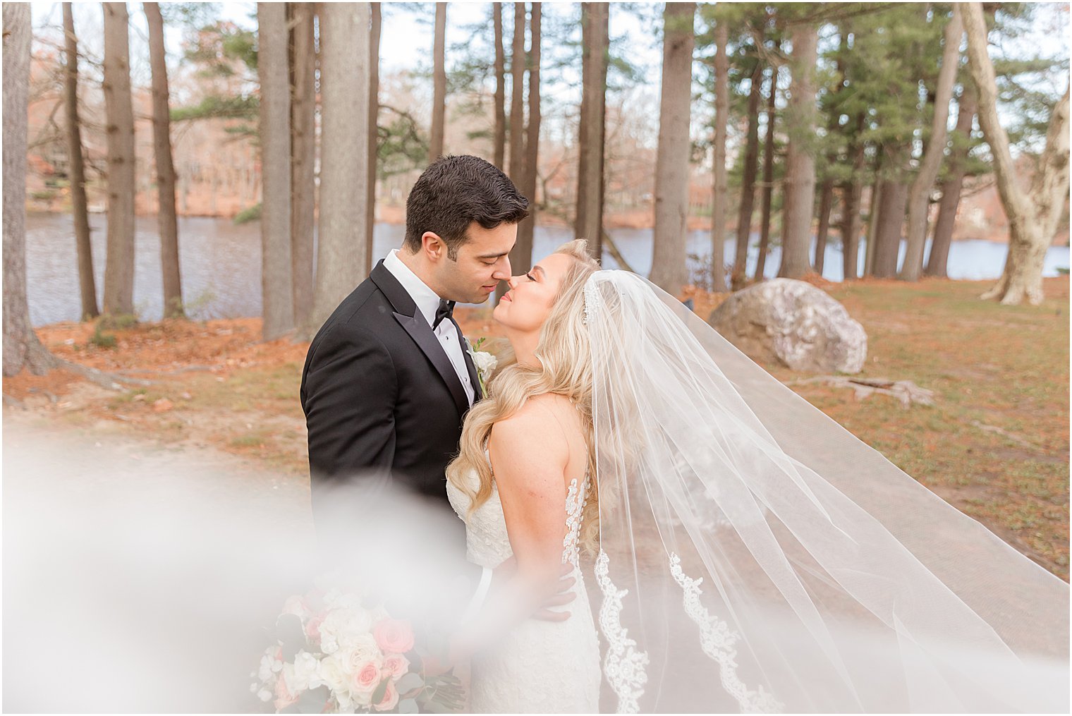 bride and groom touch noses during NJ wedding portraits at the Estate at Farmington Lake