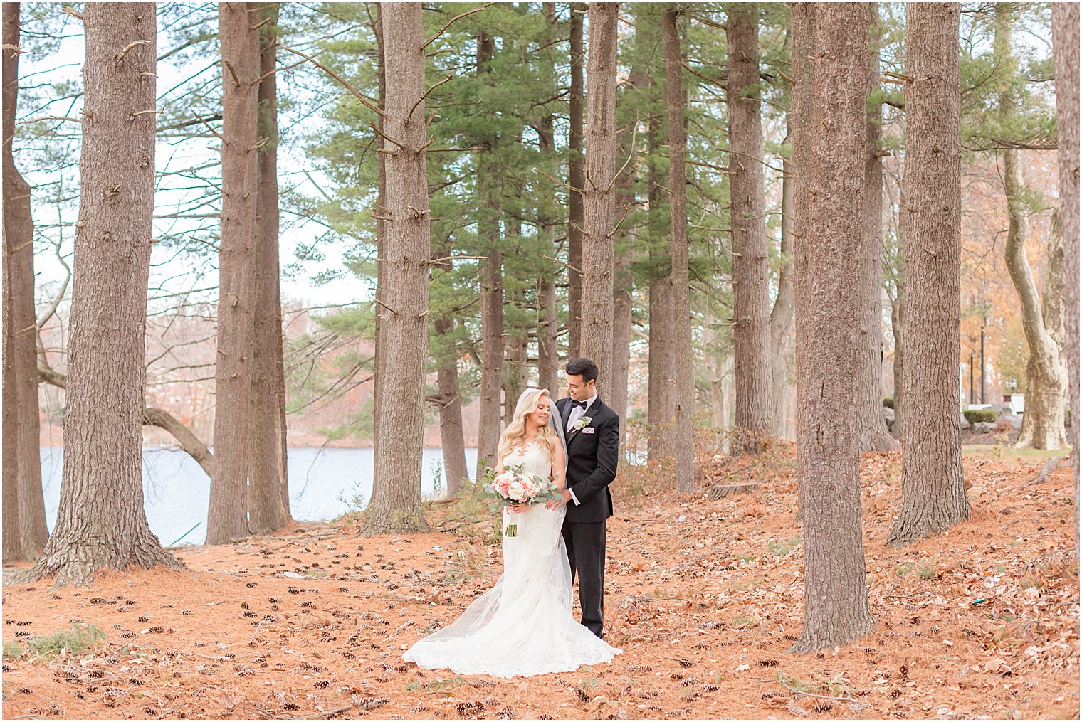 groom hugs bride from behind during portraits in the woods