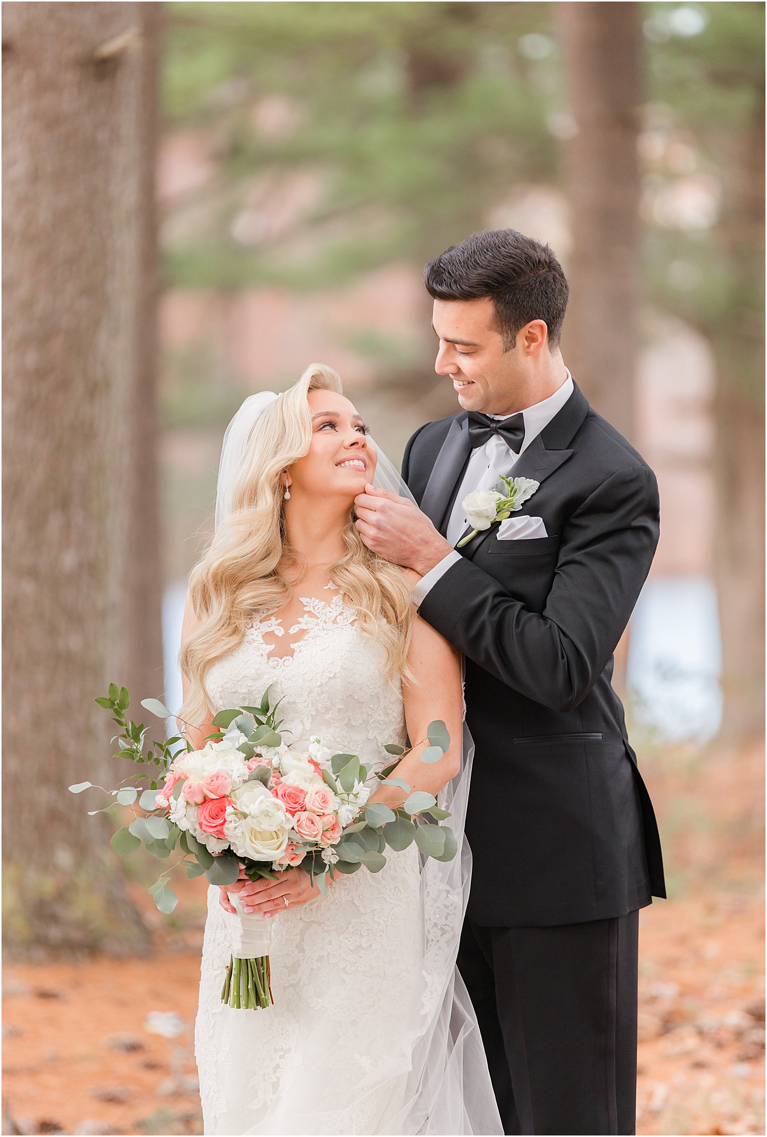 groom touches bride's chin during winter wedding portraits at the Estate at Farmington Lake