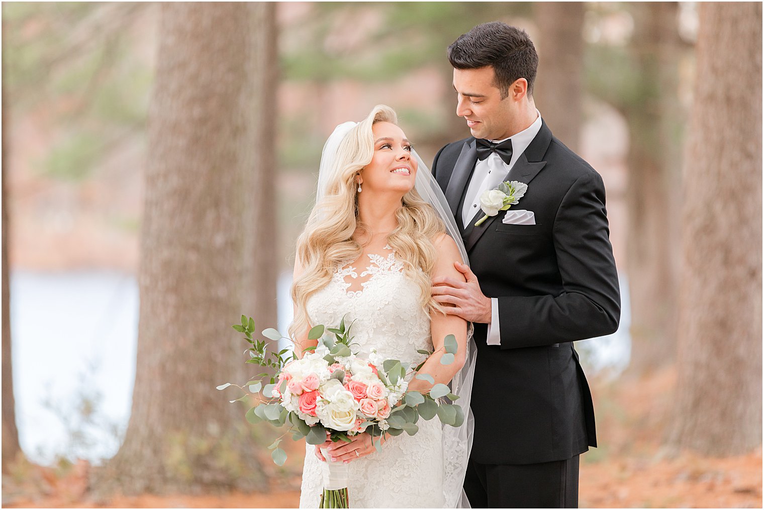 groom looks down at bride during winter wedding portraits 