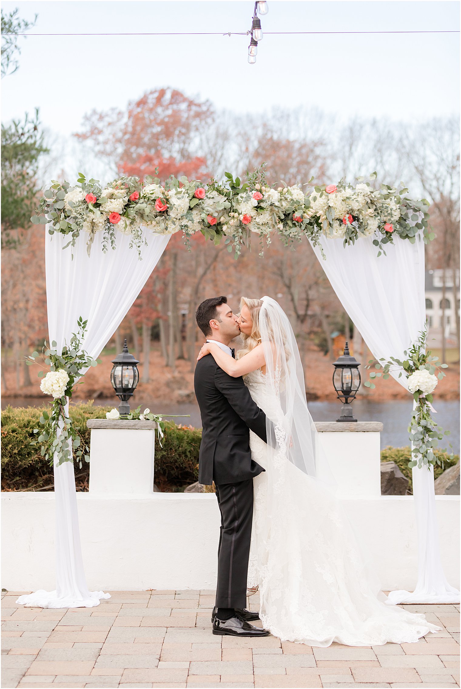 groom lifts bride up by arbor at the Estate at Farmington Lake