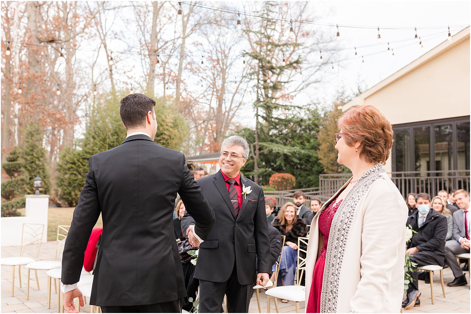 groom's parents shake hands with him before outdoor wedding ceremony in East Brunswick NJ