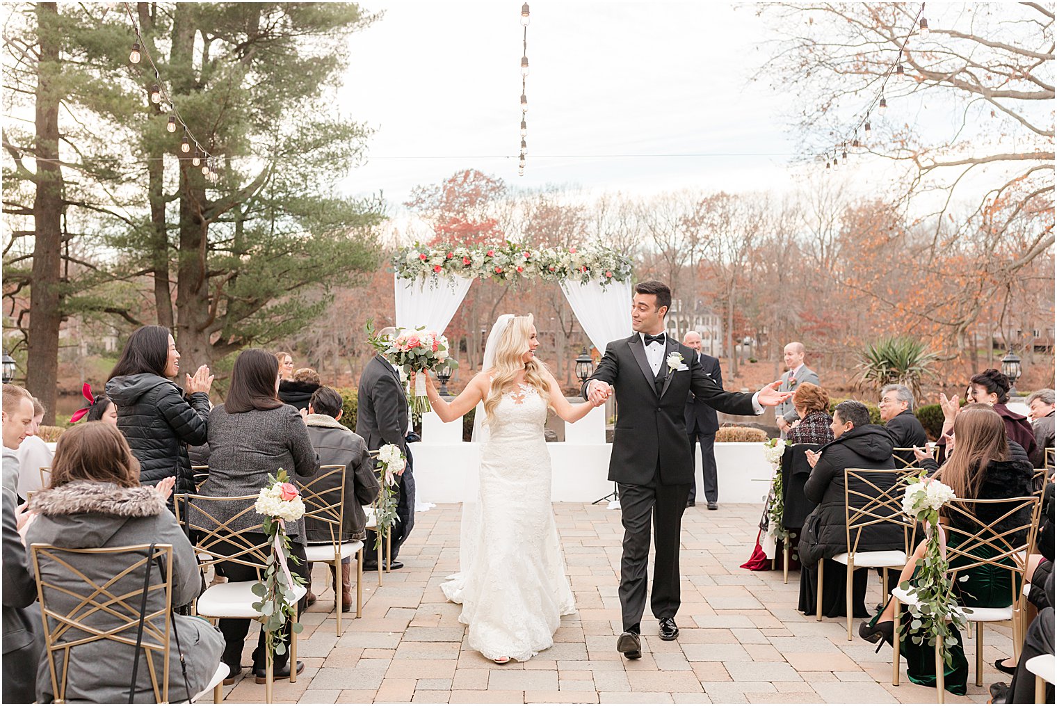 bride and groom hold hands walking up aisle after wedding ceremony