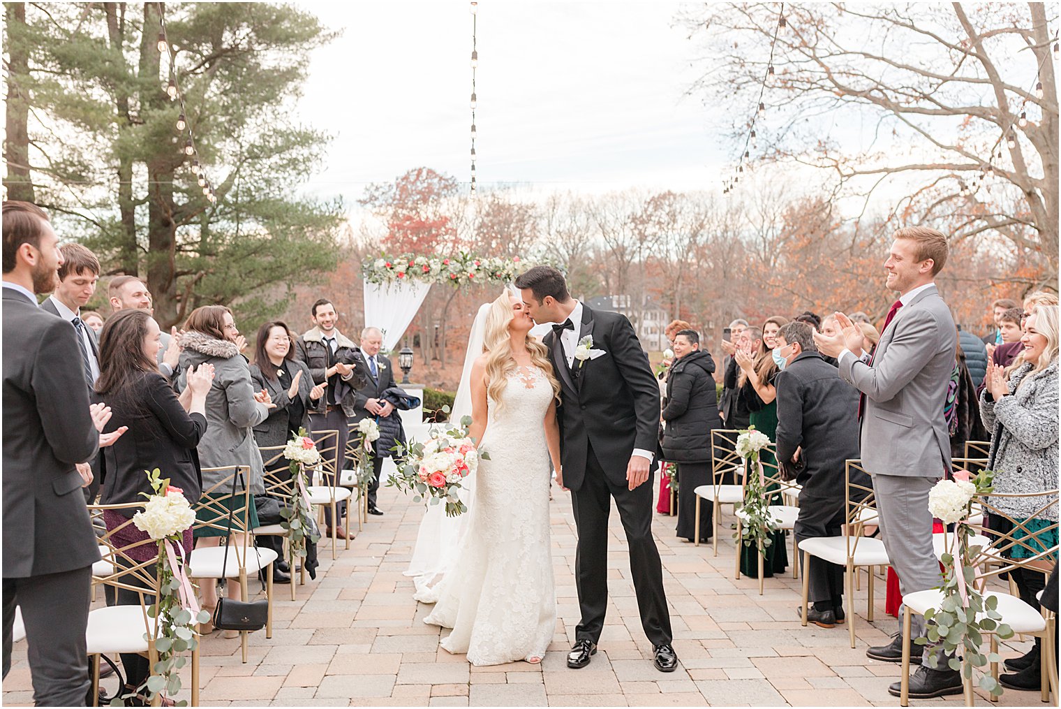 bride and groom kiss walking up aisle after ceremony outside at the Estate at Farrington Lake