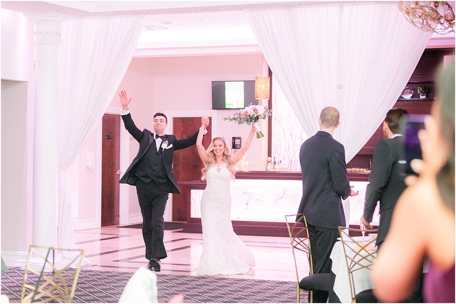 newlyweds cheer walking into wedding reception at the Estate at Farrington Lake