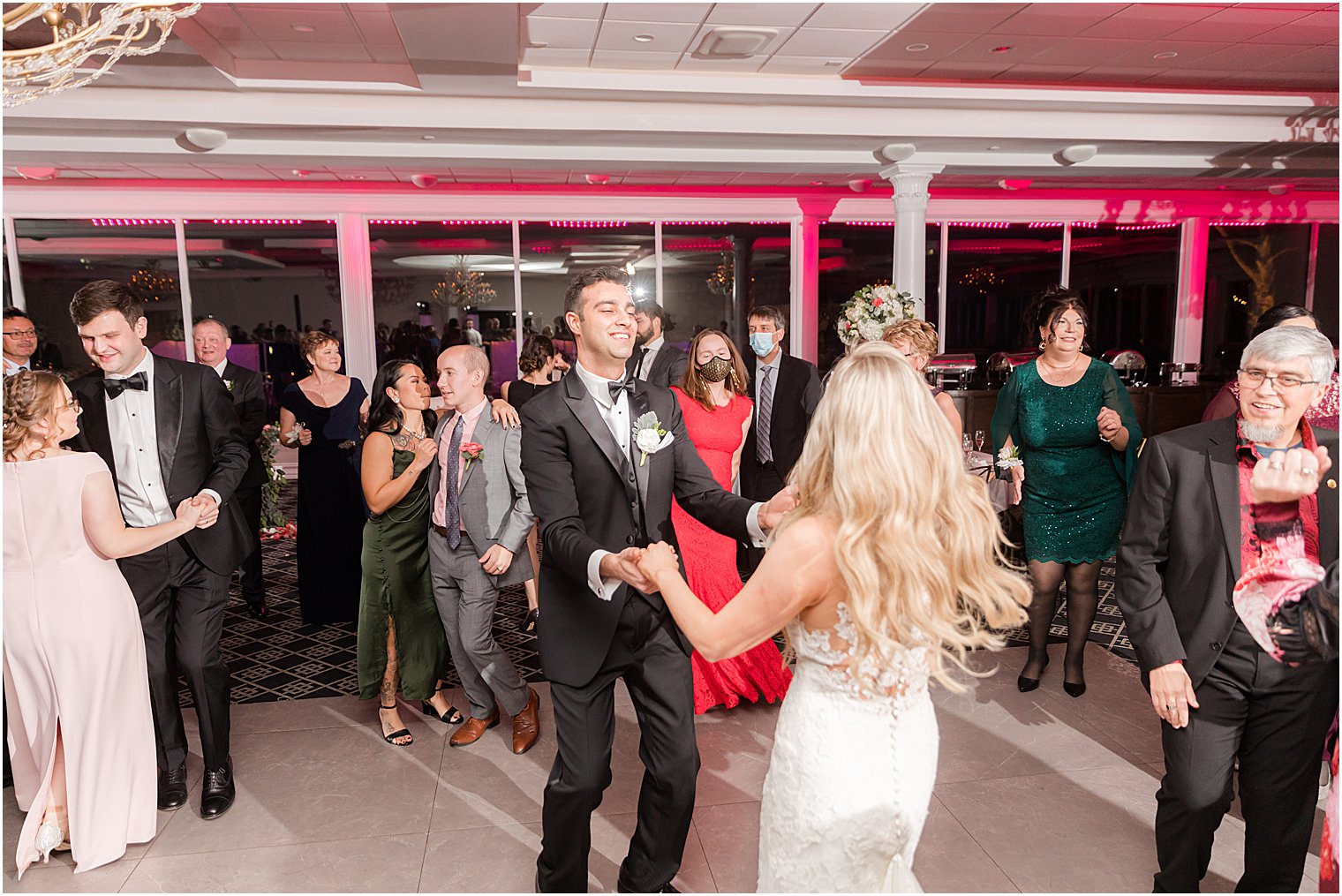 bride and groom hold hands dancing with guests at the Estate at Farrington Lake