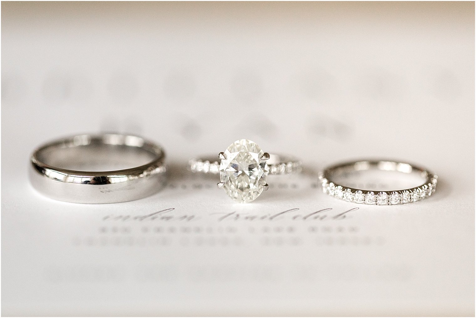 wedding rings rest on invitation for winter wedding at Indian Trail Club