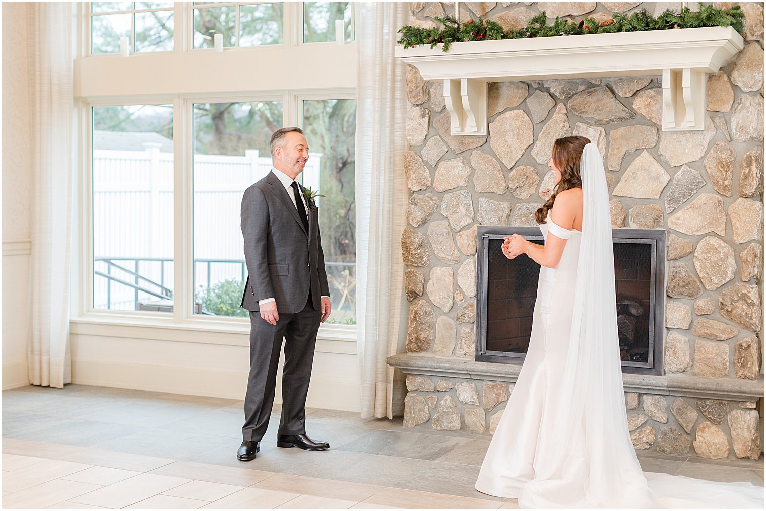 bride and dad have first look by stone fireplace