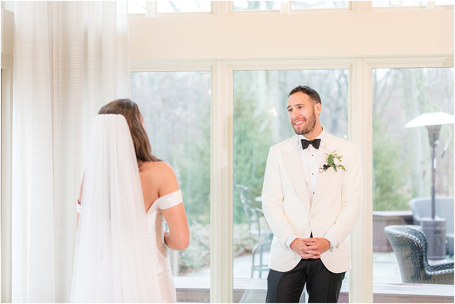 groom smiles at bride during first look 