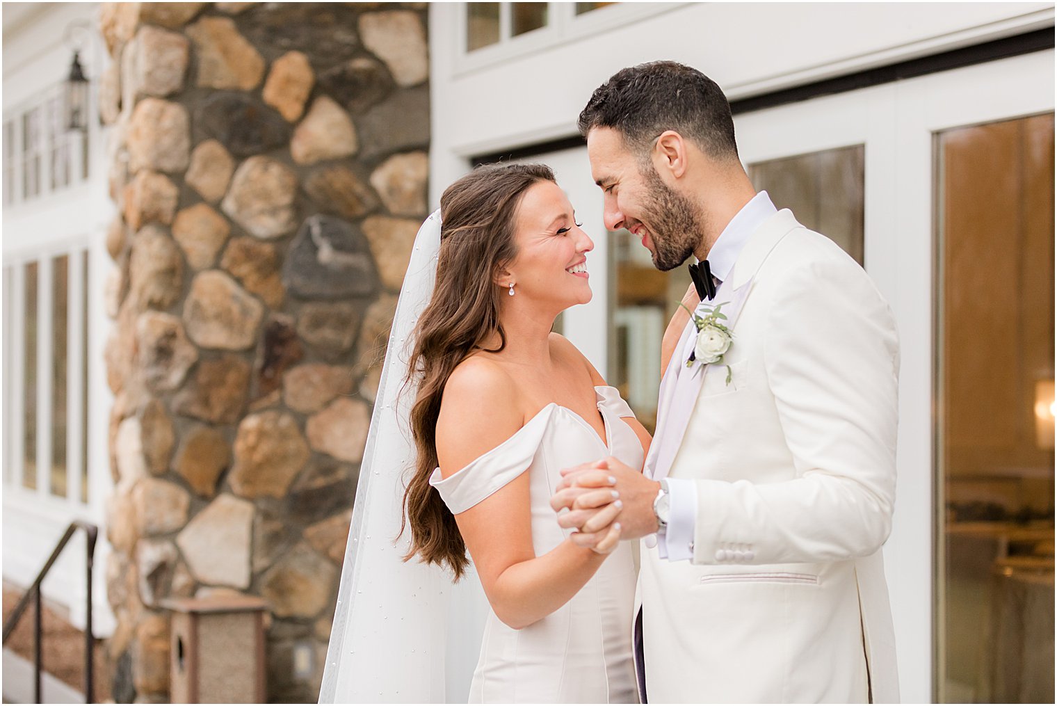 bride and groom dance during winter wedding portraits on patio at Indian Trail Club