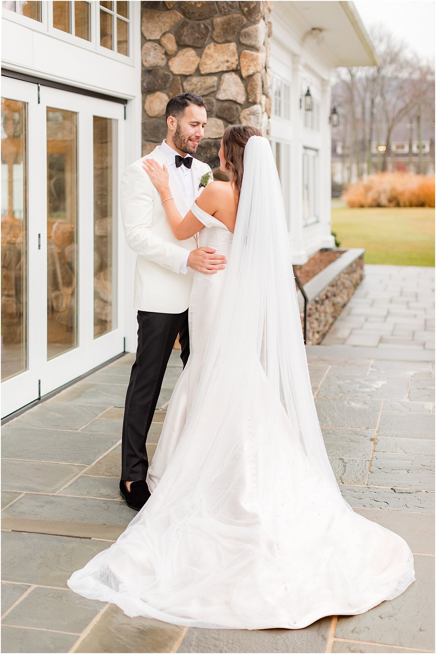 bride and groom hug on patio at Indian Trail Club