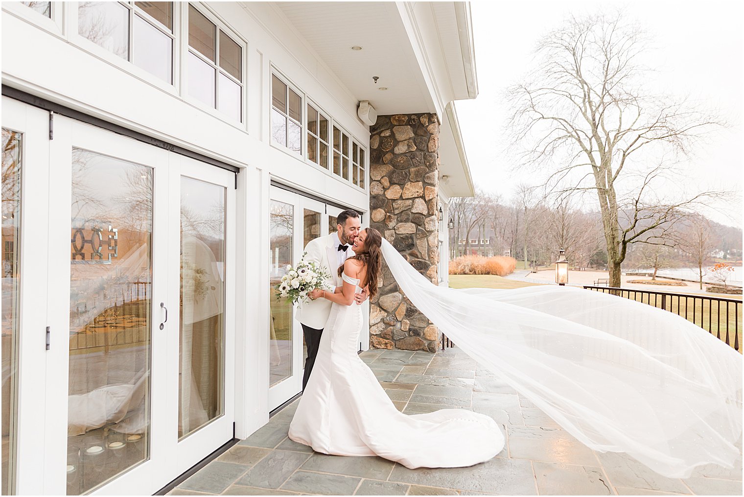 groom kisses bride's cheek during portrait at Indian Trail Club