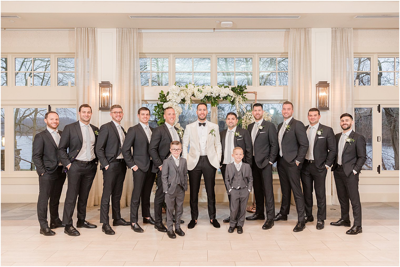 groom stand with groomsmen in grey suits