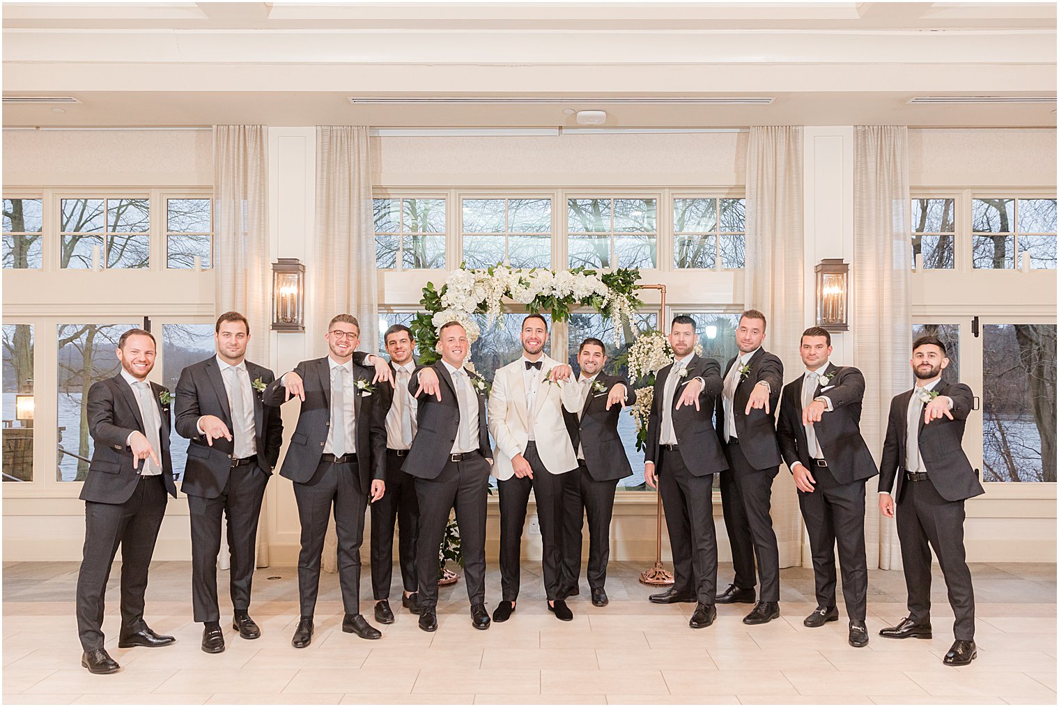 groom in white tux jacket poses with groomsmen at Indian Trail Club