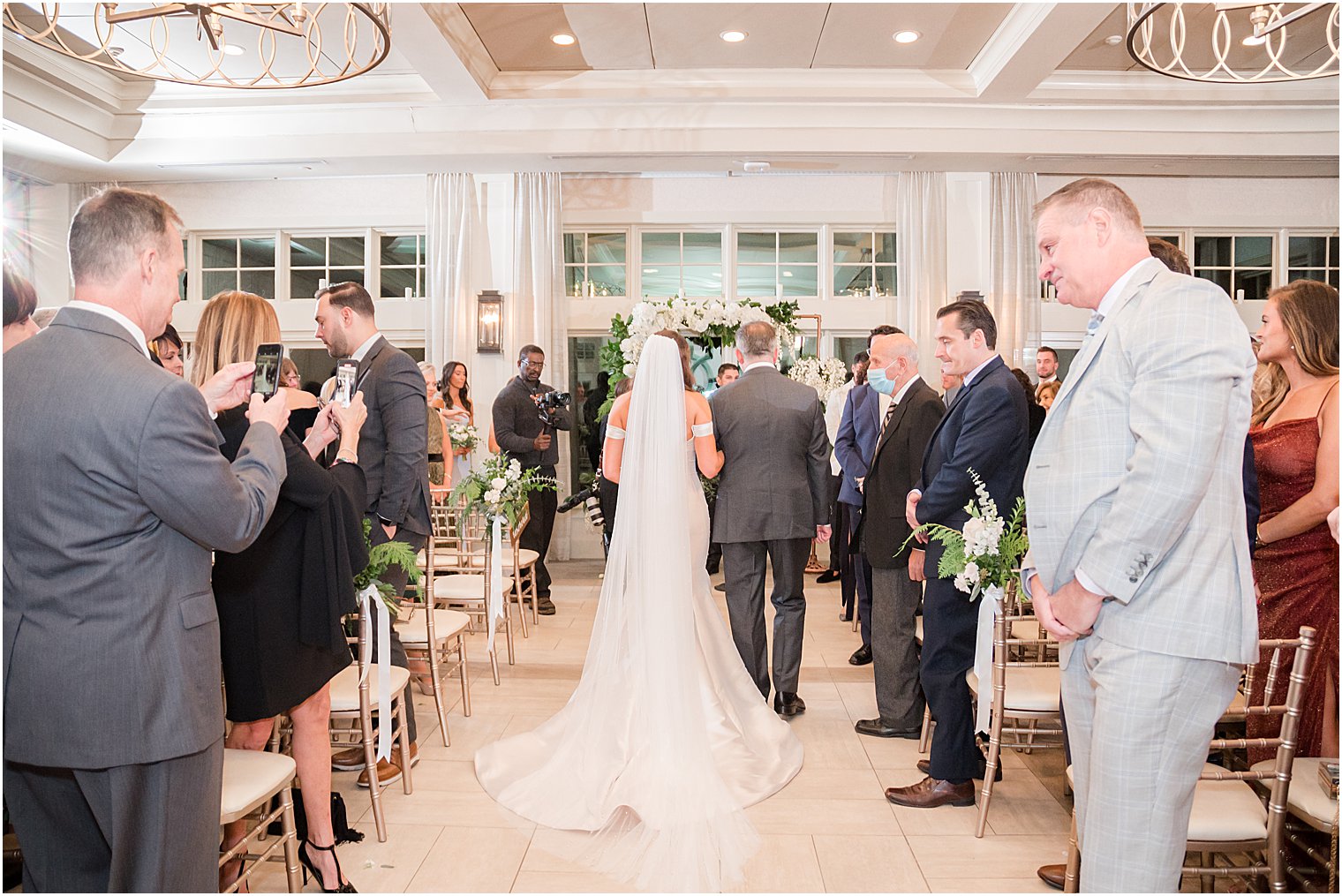 bride walks down aisle with parents during Jewish wedding ceremony in Franklin Lakes NJ