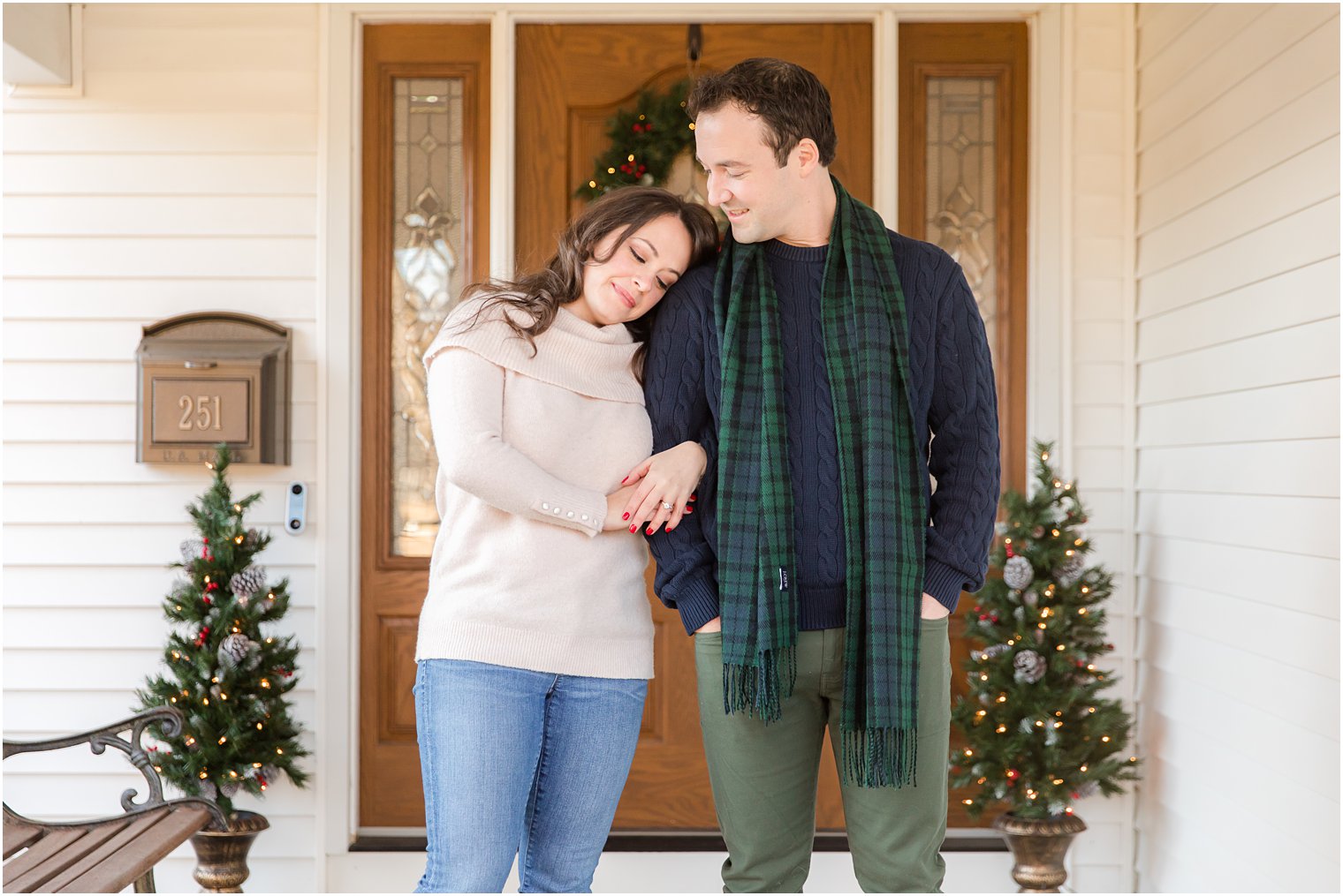 engaged couple stands by front door at New Jersey home for engagement photos 
