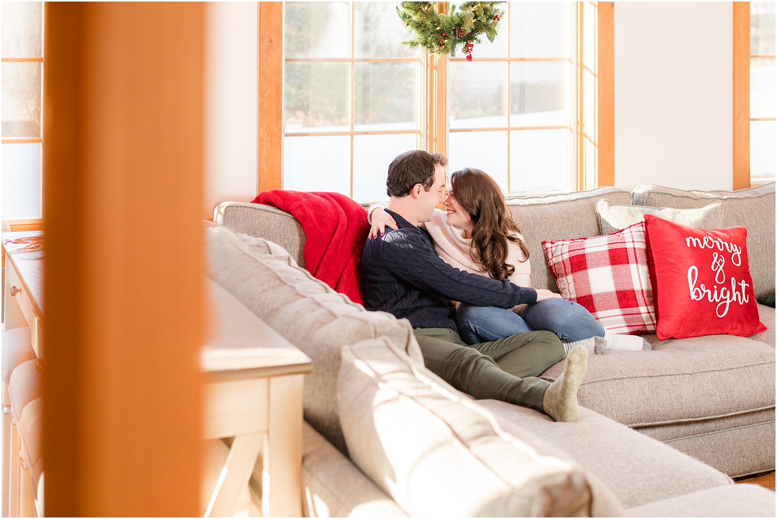 bride and groom snuggle on couch during photos at home 