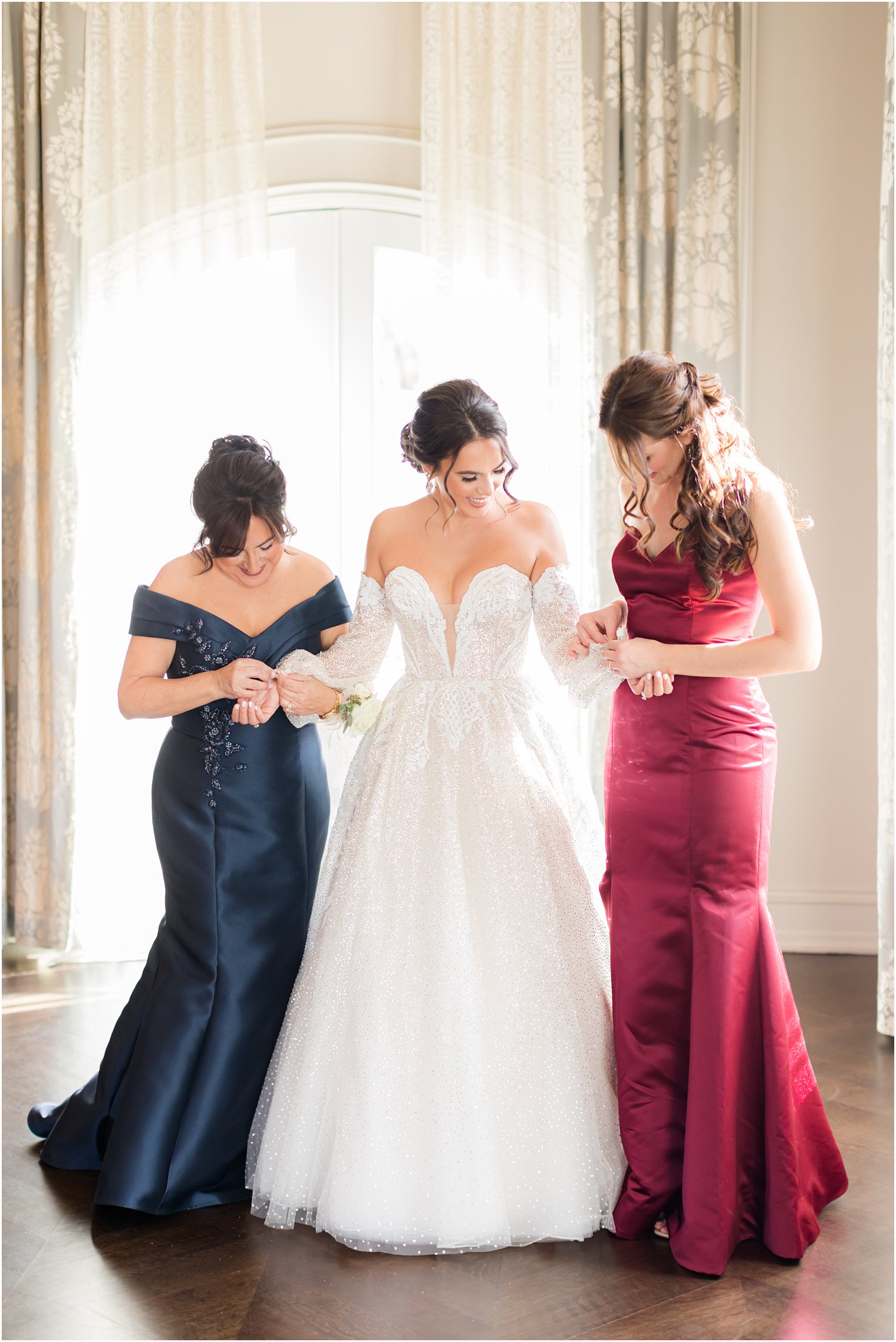 bridesmaid and mom help bride with sleeves on wedding dress at Park Chateau Estate