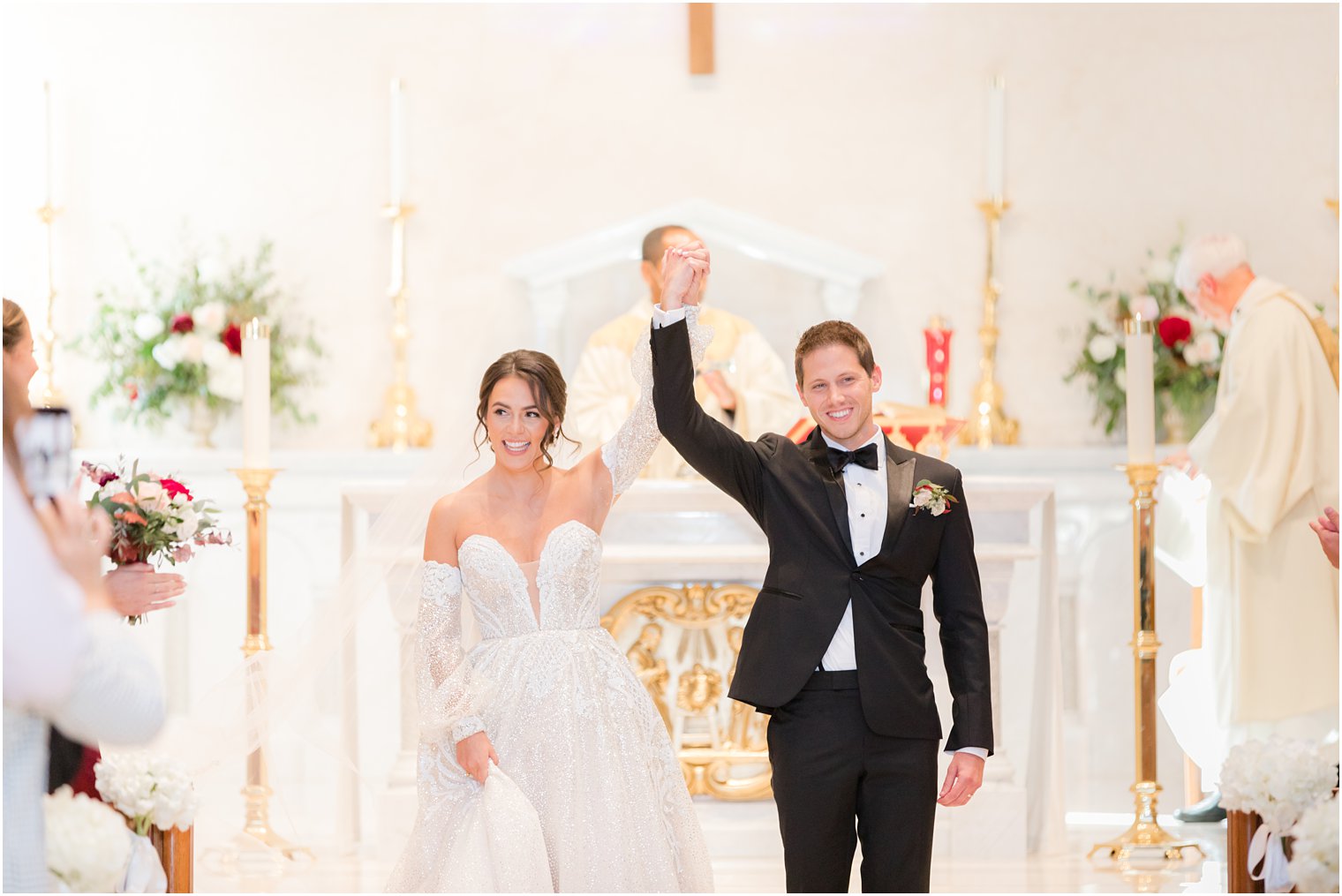 bride and groom cheer walking up aisle after NJ church wedding ceremony