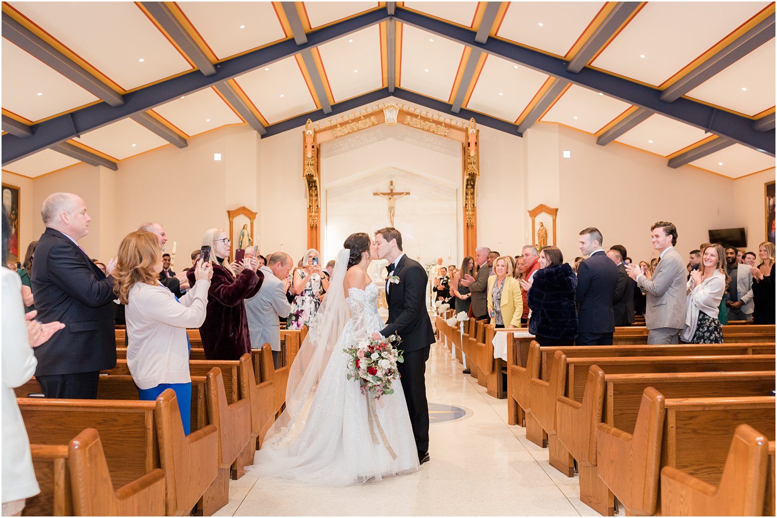 couple kisses in aisle of New Jersey church after ceremony 
